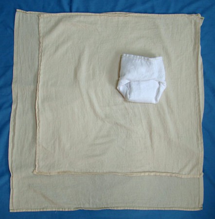 the larger flat is folded to create a diaper of this size. a cover...
