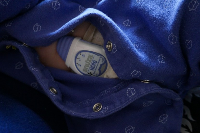 snuza hero se - the snuza hero attached to the diaper under a one-piece sleeper...