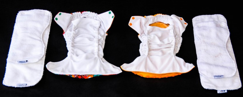 two rumparooz diapers laid side by side with their inserts.