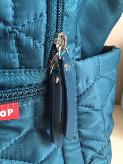 closeup of the dual zippers on the large middle pocket.