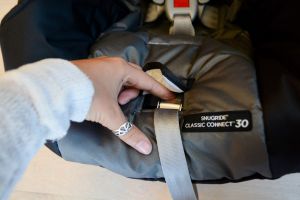 graco snugride classic connect 30 infant car seat review - the harness release button is easy to access on the graco 30