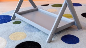 The UPPAbaby has a painted or stained wood stand with a flat storage...