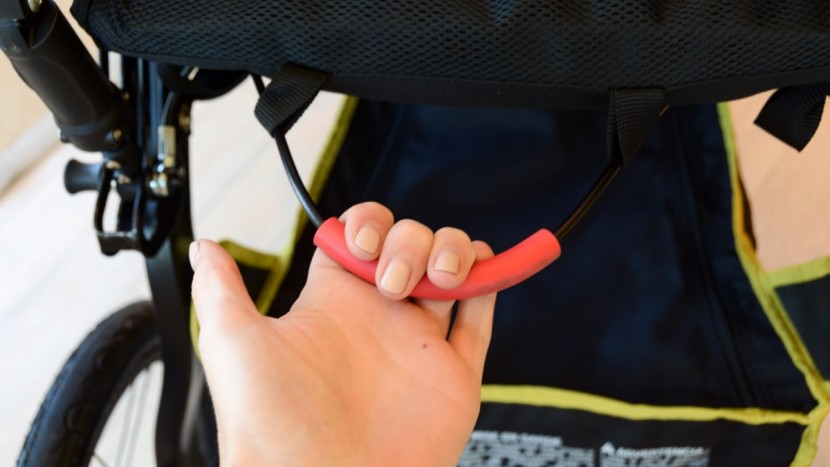 the blaze folding handle is located under the seat and from behind.