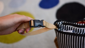 A buckle strap on the side of the bag allows you to clip it to your...