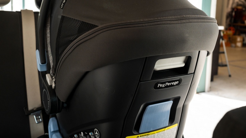 peg perego primo viaggio 4-35 nido - the back of the nido carrier has the release lever and the shoulder...