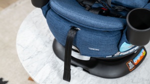 The harness tightening strap and release button are located on the...