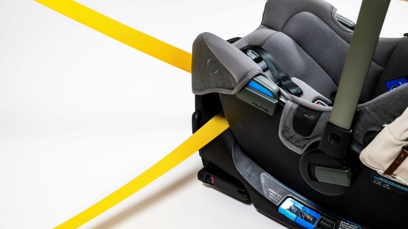 the belt pathway on the nuna runs through the base near the foot end.