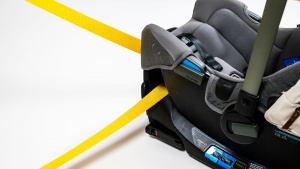 The belt pathway on the Nuna runs through the base near the foot end.